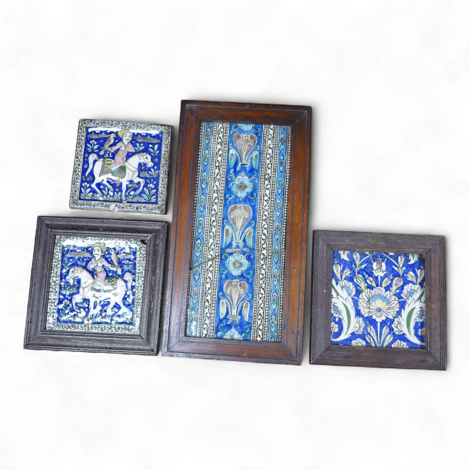 Four 18th/19th century Persian tiles, two depicting horses and riders and abstract flowers, three framed, largest 40 x 21cm